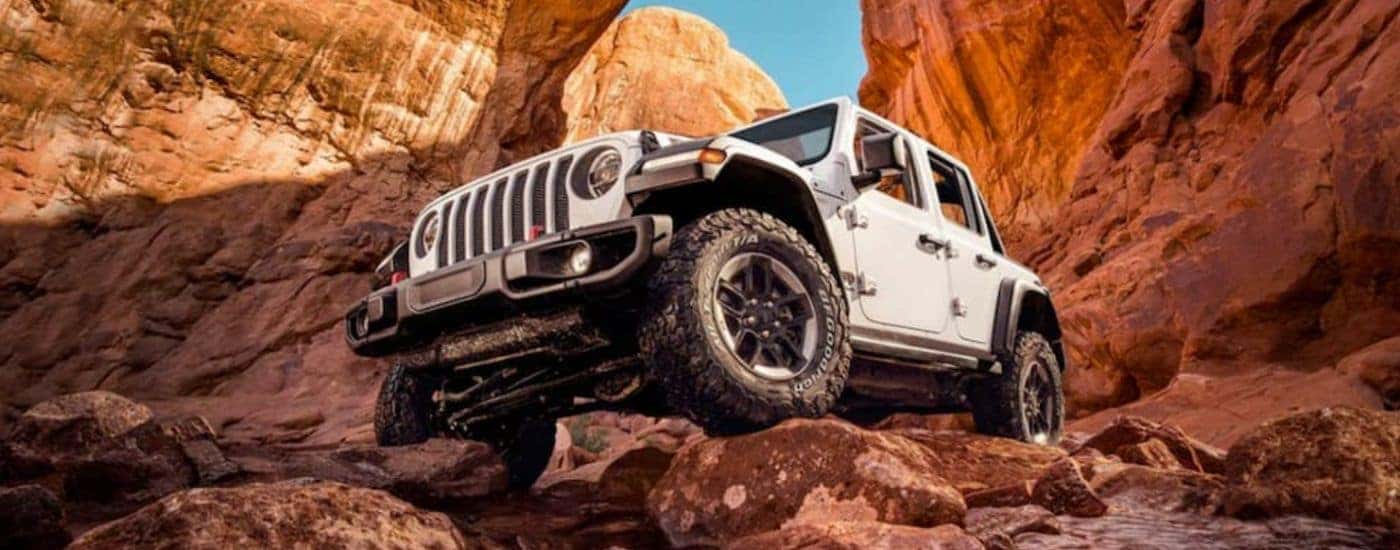 A white 2021 Jeep Wrangler Unlimited is parked on a rock formation.