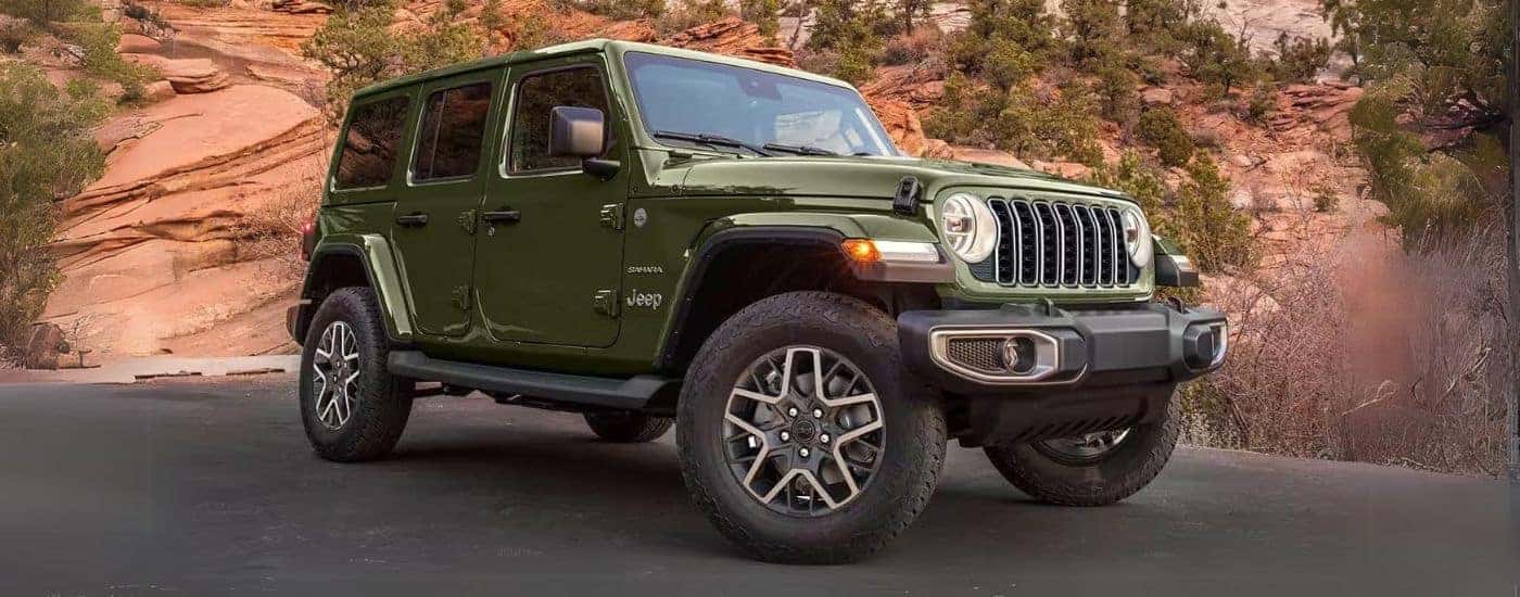 A green 2024 Jeep Wrangler Sahara Unlimited parked off-road