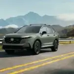 2026 Honda CR-V Hybrid near Smithtown NY driving on a scenic highway with mountains, showing smooth long drive efficiency