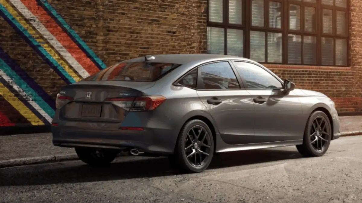 2026 Honda Civic Sedan near Smithtown, NY, rear three quarter view parked on a city street by a brick wall mural