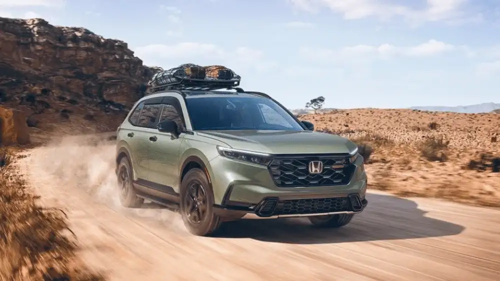 2026 Honda CR-V near Smithtown NY driving on a dusty road with roof rack, rugged SUV look for daily use comparisons