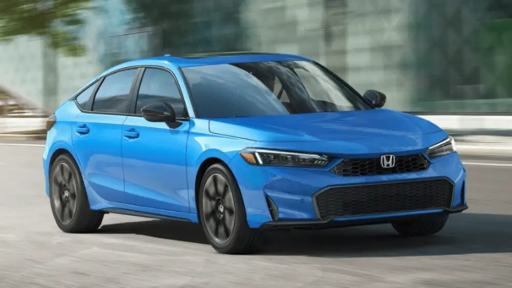 2026 Honda Civic Hatchback near Smithtown, NY blue hatchback driving on the road, front exterior angle.