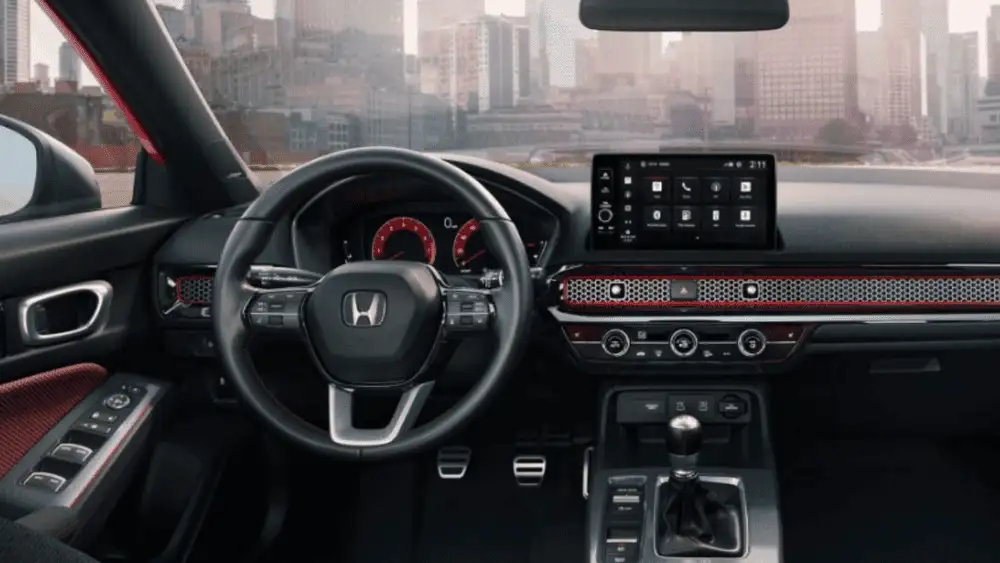 2026 Honda Civic Si near Smithtown, NY sport cockpit with red accents, infotainment screen, and manual shifter.