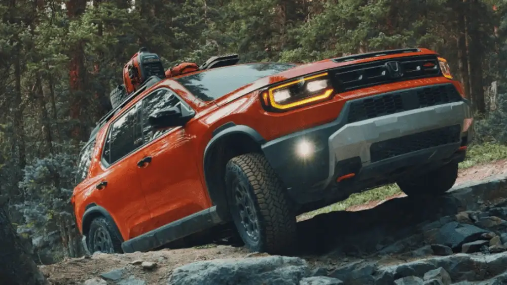 2026 Honda Passport near Smithtown, NY TrailSport driving over rocky terrain with roof gear for an off-road adventure