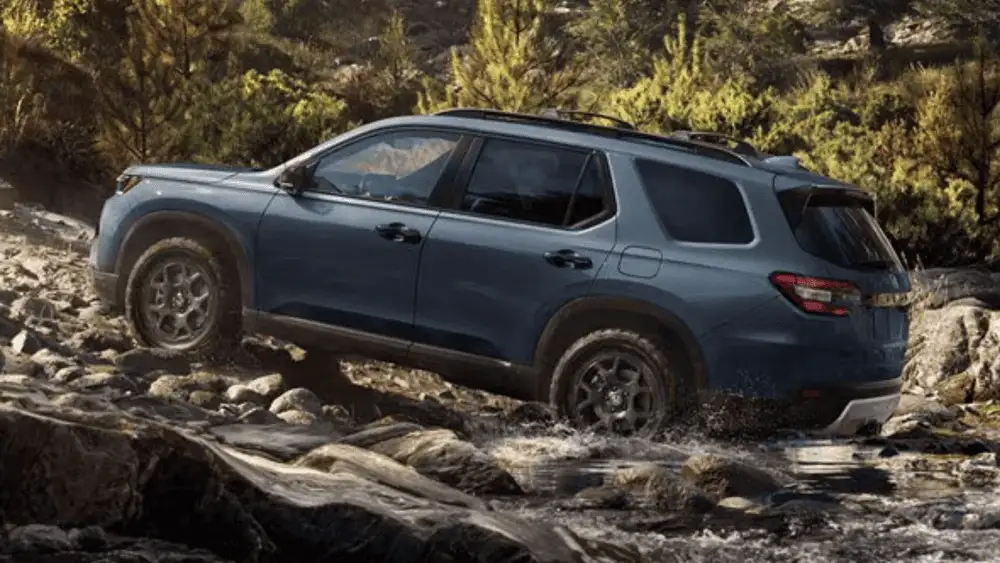 2025 Honda Pilot near Smithtown, NY driving on the road, showing a roomy family SUV with a clean rear view.