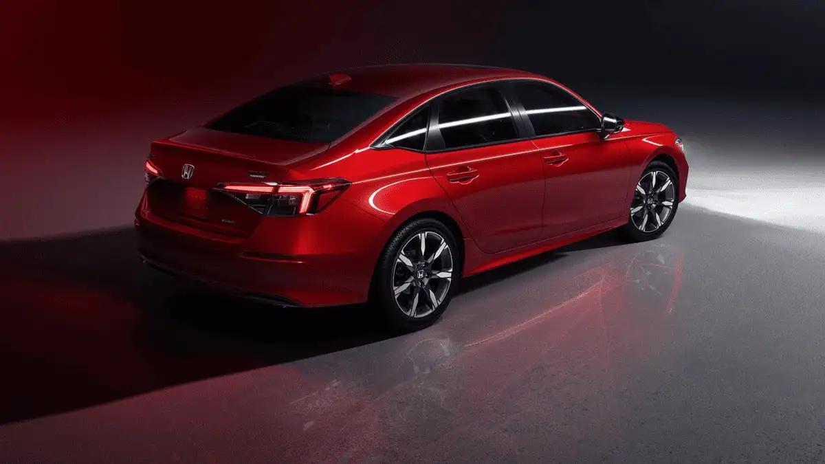 2026 Honda Civic Sedan Hybrid near Smithtown, NY red sedan parked in a studio setting, rear three-quarter view with sleek lines