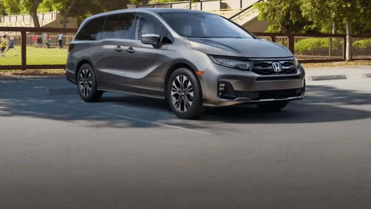 2026 Honda Odyssey near Smithtown, NY gray minivan driving near a park, front three-quarter view with kids playing in background