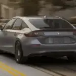 2026 Honda Civic Hatchback Hybrid near Smithtown NY driving through the city, rear three-quarter view highlighting sporty hatchback design