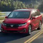 2026 Honda Odyssey around Smithtown NY driving on the highway, front view of a red minivan built for family trips and comfort