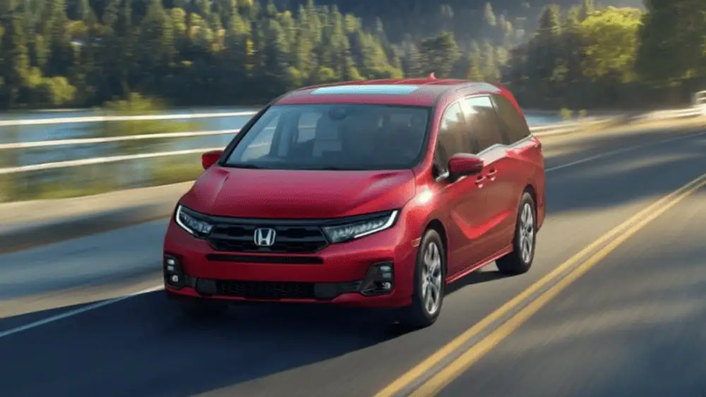 2026 Honda Odyssey around Smithtown NY driving on the highway, front view of a red minivan built for family trips and comfort