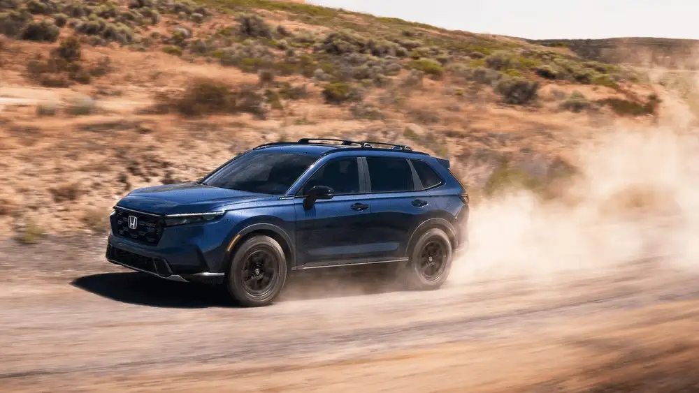 2026 Honda CR-V in Aegean Blue Metallic driving on dusty off-road trail near Commack NY