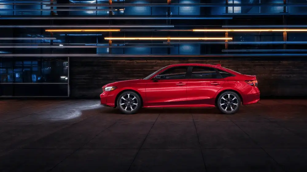 2026 Honda Civic Sedan in Rallye Red parked in dramatic urban setting at night near Commack NY