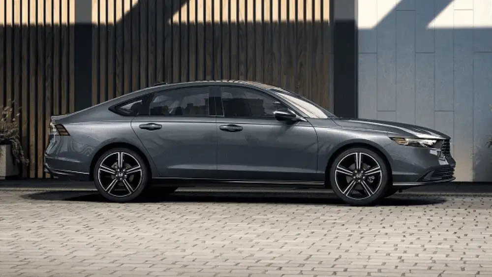 2026 Honda Accord Hybrid in Sonic Gray Pearl side profile parked on cobblestone — efficient earnings for rideshare drivers near Commack NY