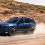 2026 Honda CR-V in Aegean Blue Metallic with roof rails driving on dusty trail — road trip ready cargo solutions for families near Commack NY