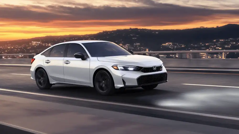 2026 Honda Civic Si in Platinum White Pearl side profile driving on highway at sunset near Commack NY