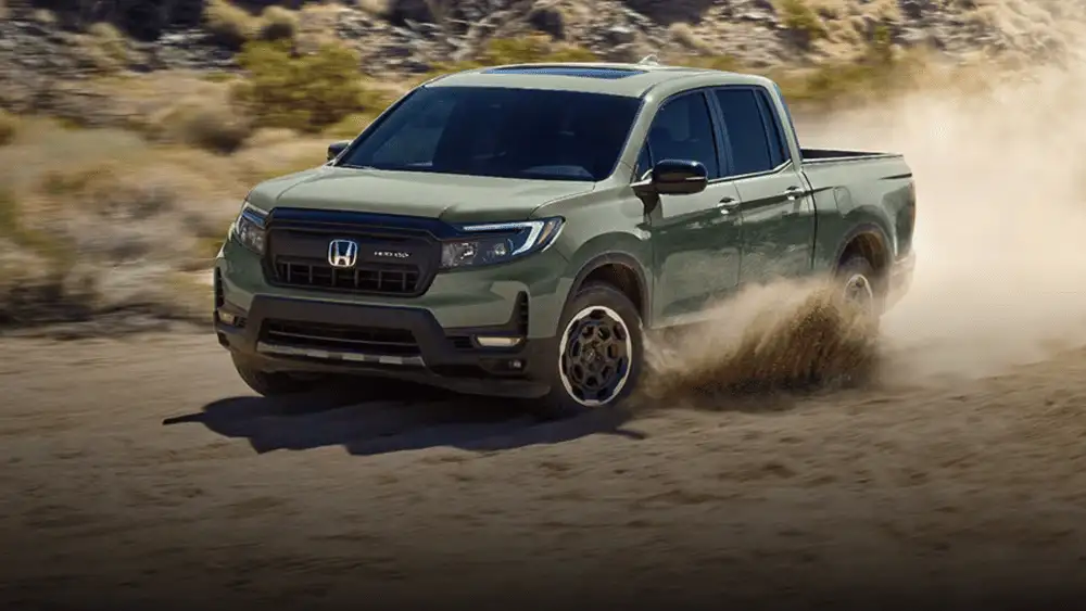 2026 Honda Ridgeline pickup truck in Seed Pearl Metallic front three-quarter view driving on dusty desert road near Commack NY