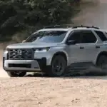 2025 Honda Pilot in Lunar Silver Metallic TrailSport front three-quarter view on dusty gravel road — best scenic drives near Commack NY
