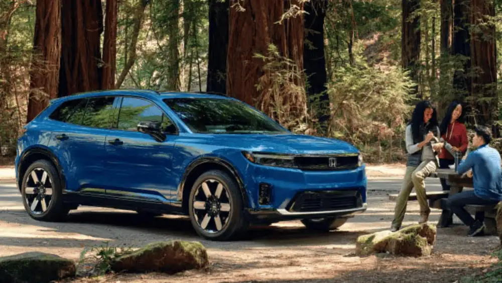 2026 Honda Prologue electric SUV in blue parked in forest while group relaxes nearby — charging around Commack NY made simple