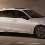 2026 Honda Civic Hatchback in Platinum White Pearl side profile driving through tunnel — compact convenience near Commack NY