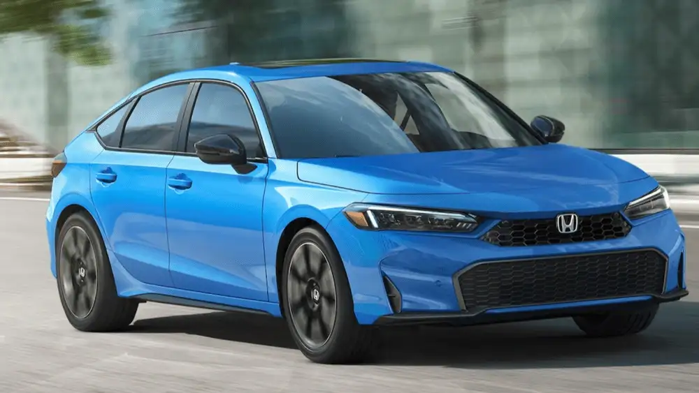 2026 Honda Civic Hatchback Hybrid in Boost Blue Metallic front three-quarter view driving on city road