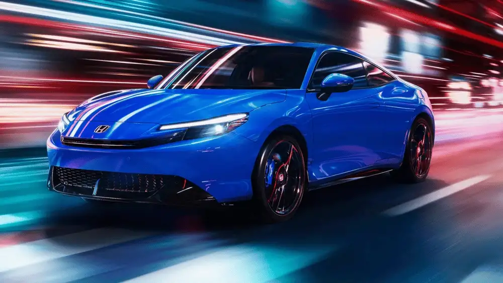 2026 Honda Prelude Hybrid in Boost Blue front three-quarter view driving through neon-lit city street at night