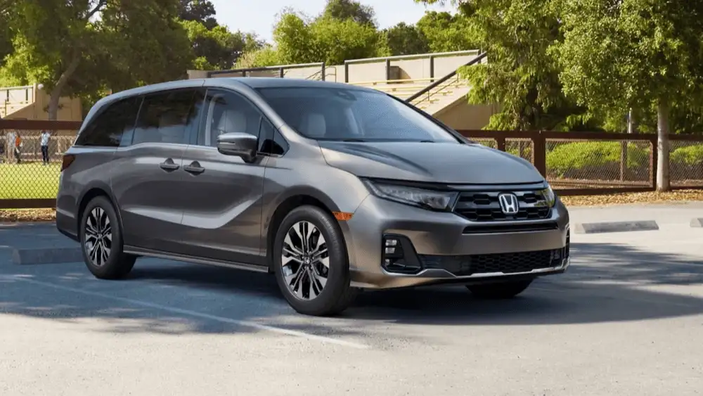 Gray 2026 Honda Odyssey minivan parked near a park, comparing it to the Kia Carnival around Commack NY