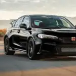 Black 2025 Honda Civic Type R speeding down a desert track at sunset, built for turbocharged fun for Commack drivers