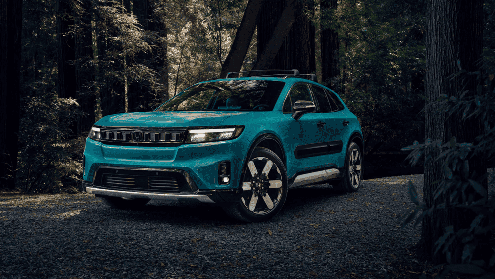 Teal 2026 Honda Prologue electric SUV parked on a forest gravel path at night near Hauppauge NY