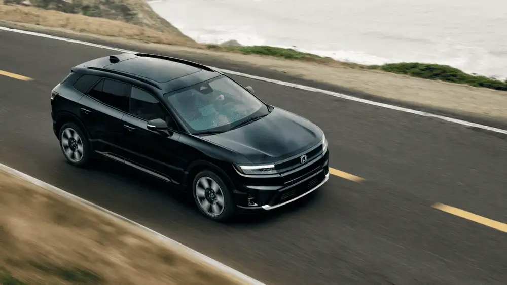 Black 2026 Honda Prologue electric SUV driving along a coastal highway, a top pick for EV buyers near Hauppauge NY