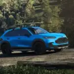 Blue 2026 Honda HR-V with a surfboard on the roof rack parked by a lakeside trail, a great first SUV near Hauppauge NY
