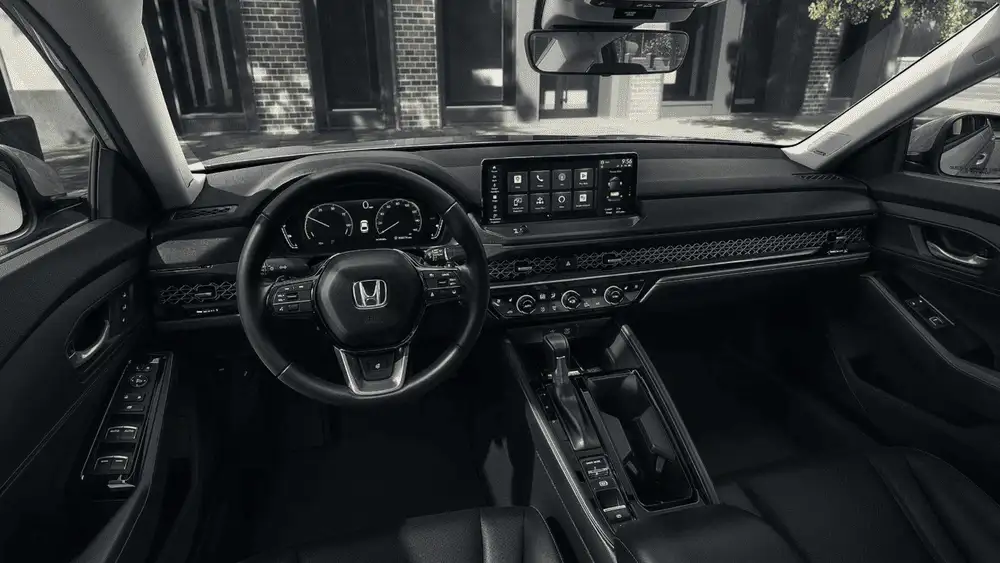 Black interior of a 2026 Honda Accord Hybrid near Hauppauge, NY, showing the dashboard, steering wheel, and touchscreen display.
