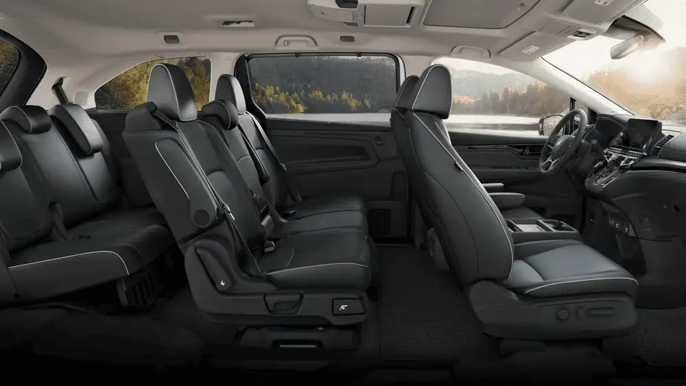 Black leather seats inside a 2026 Honda Odyssey near Hauppauge, NY, with a side view of three rows of seating.