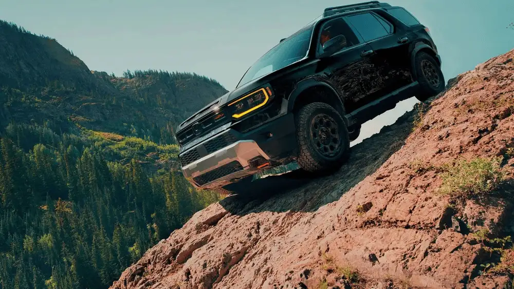 Black 2026 Honda Passport near Hauppauge, NY, climbing a rocky trail in a mountain forest.