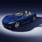 Overhead shot of a dark blue 2019 Maserati GranTurismo Convertible with the top down in a dark room illuminated by a spotlight