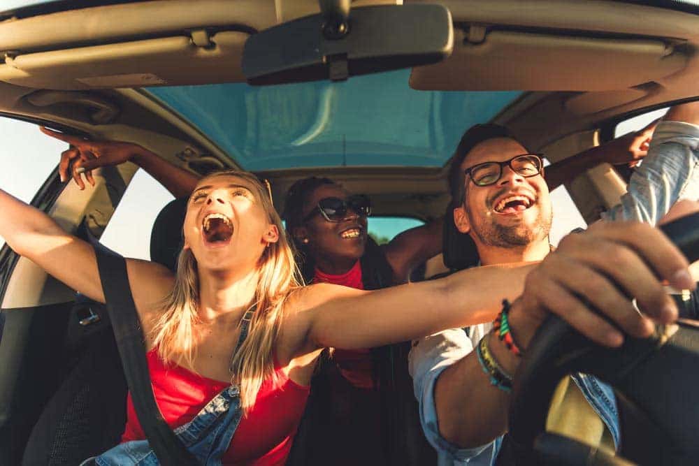 friends cheering in a car