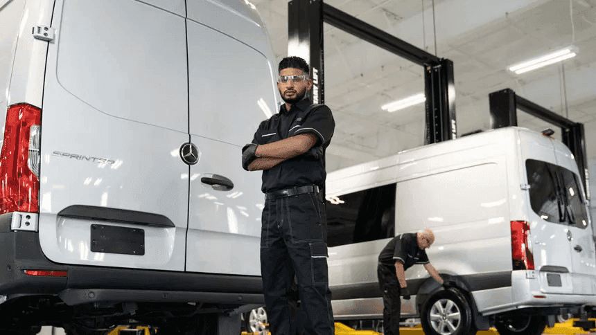 A service technician standing in front of the rear doors of a Mercedes-Benz Sprinter Van
