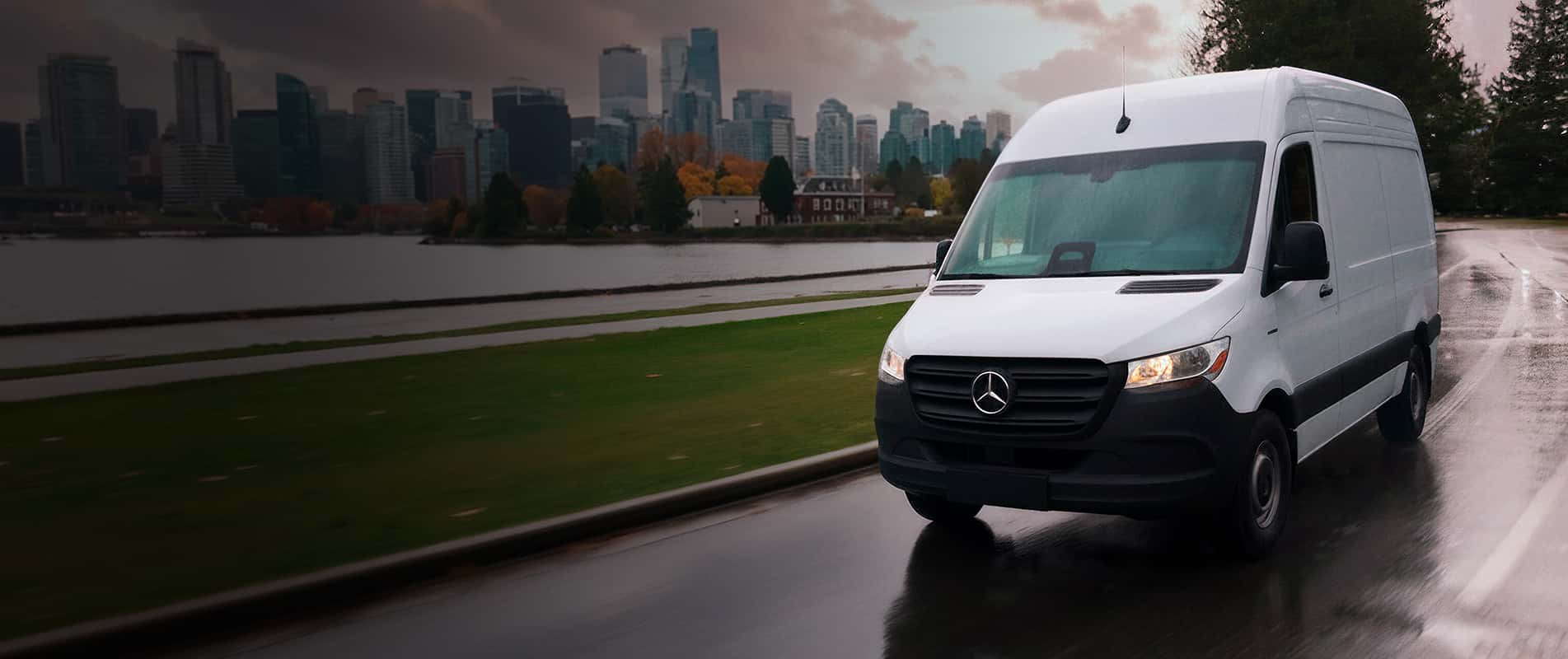 Image of Sprinter Van Driving with cityscape in background