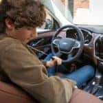 A teen driver is shown buckling into a Chevy at at Shelbyville used Chevy dealer.