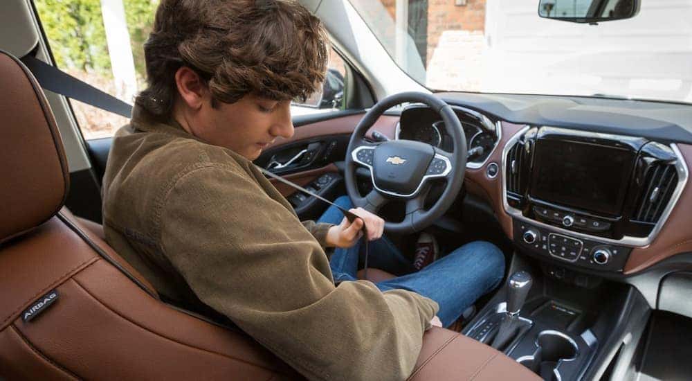 A teen driver is shown buckling into a Chevy at a Shelbyville used Chevy dealer.