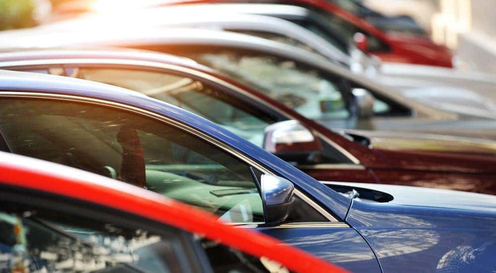 A row of cars are shown parked at a Certified Pre-Owned GMC dealer.