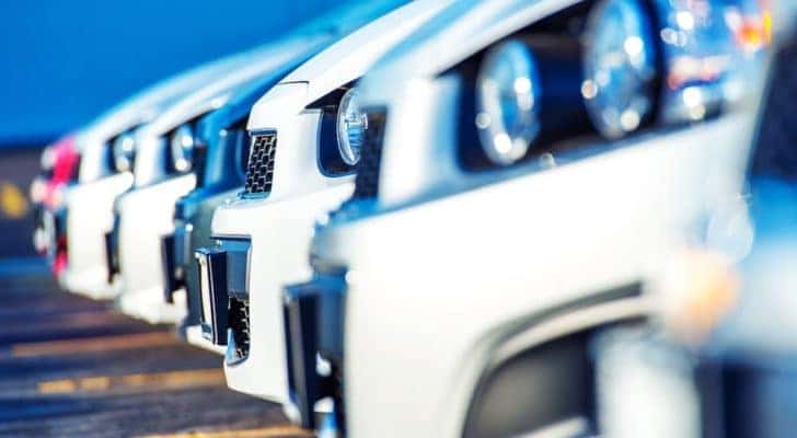 A row of cars is shown at a dealership.