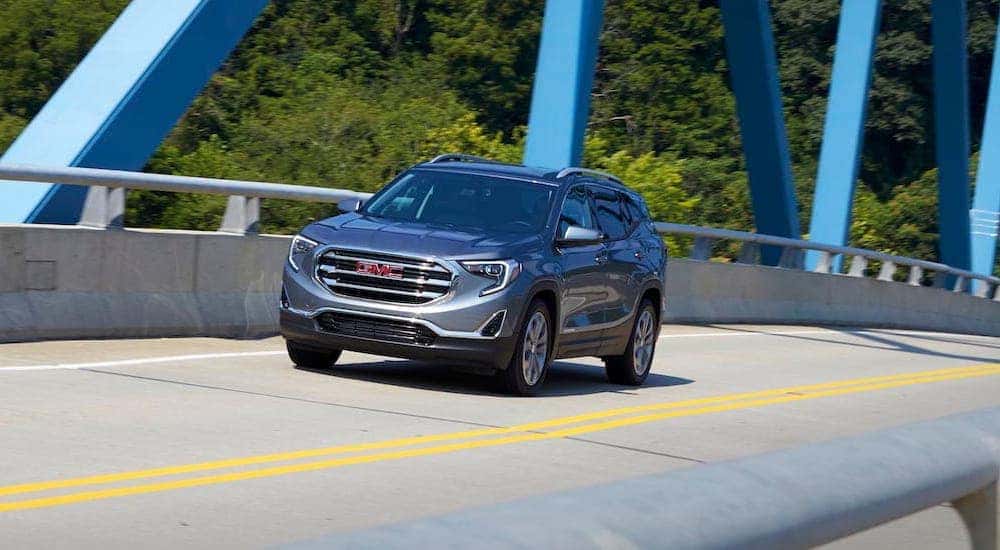 A grey 2018 GMC Terrain is shown driving over a bridge after leaving a Tennessee used car dealer.