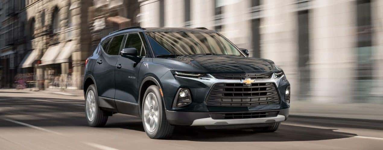A grey 2022 Chevy Blazer is shown from the front driving through a city during a 2022 Chevy Blazer vs 2022 Ford Edge comparison.