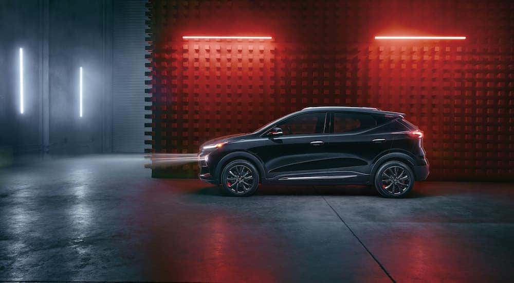 A black 2023 Chevy Bolt EUV Redline Edition is shown from the side in a warehouse after visiting a Murfreesboro Chevy dealer.