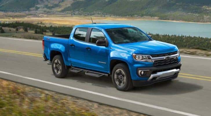 A blue 2021 Chevy Colorado is shown driving on an open road.