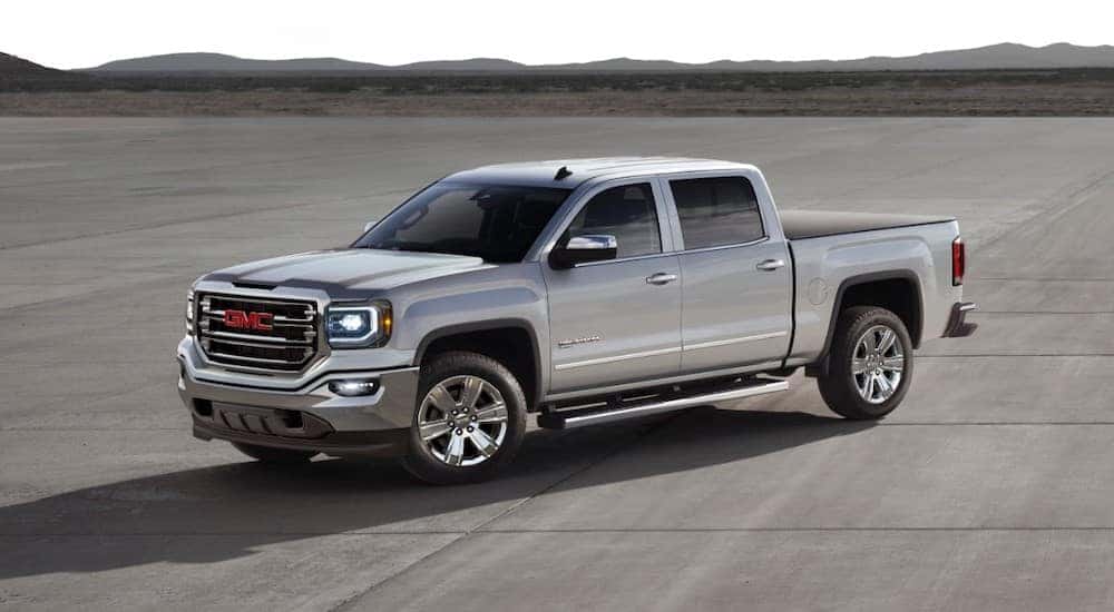 A silver 2018 GMC Sierra 1500 SLT is shown from the side while parked after the owner shopped for Shelbyville used trucks.