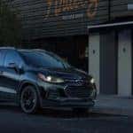 A black 2021 Chevy Trax is shown parked in front a store.