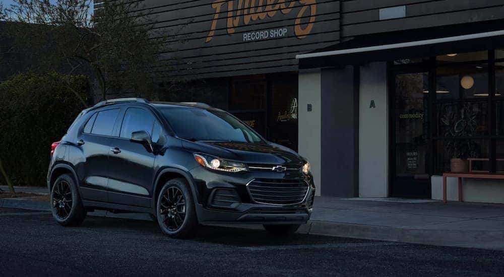 A black 2021 Chevy Trax is shown parked in front a store.