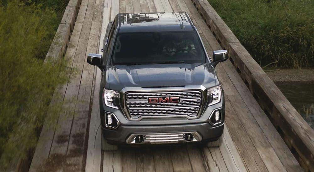 A grey 2021 GMC Sierra 1500 is shown driving on a boardwalk.
