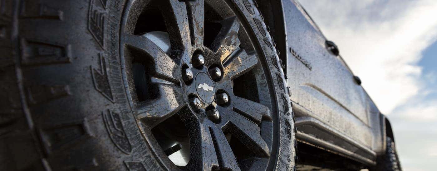 A close up shows the driver side wheels on a black 2018 Chevy Colorado ZR2 Midnight Edition.